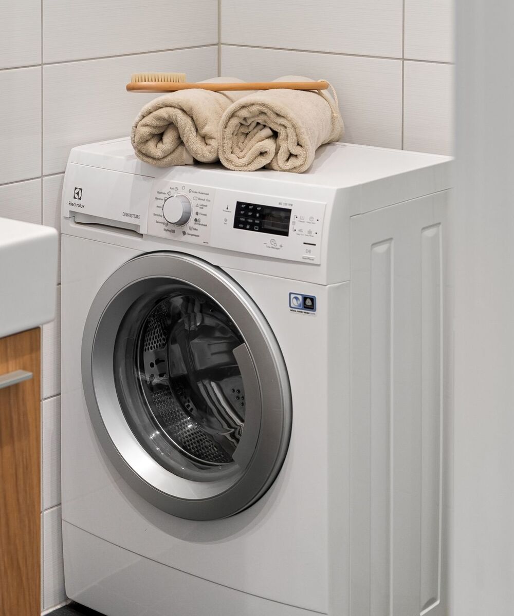 Example of a single white front-load washer with towels on top