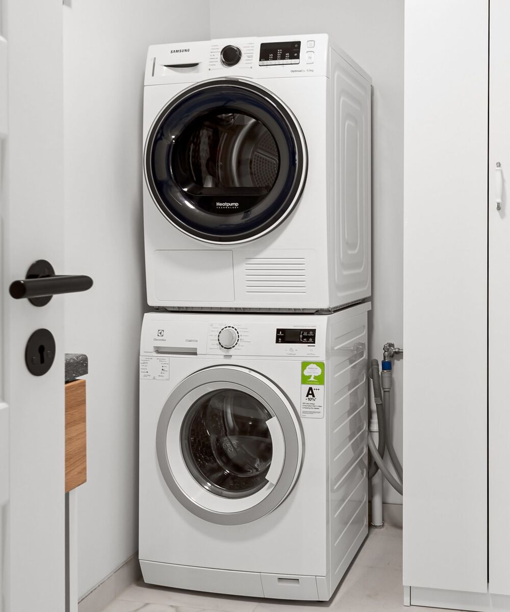 Example of a stackable washer and dryer: a white dryer on top of a white front-load washer